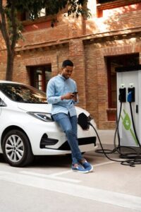 A man standing by his electric vehicle