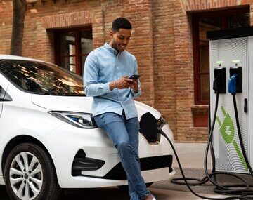 A man standing by his electric vehicle